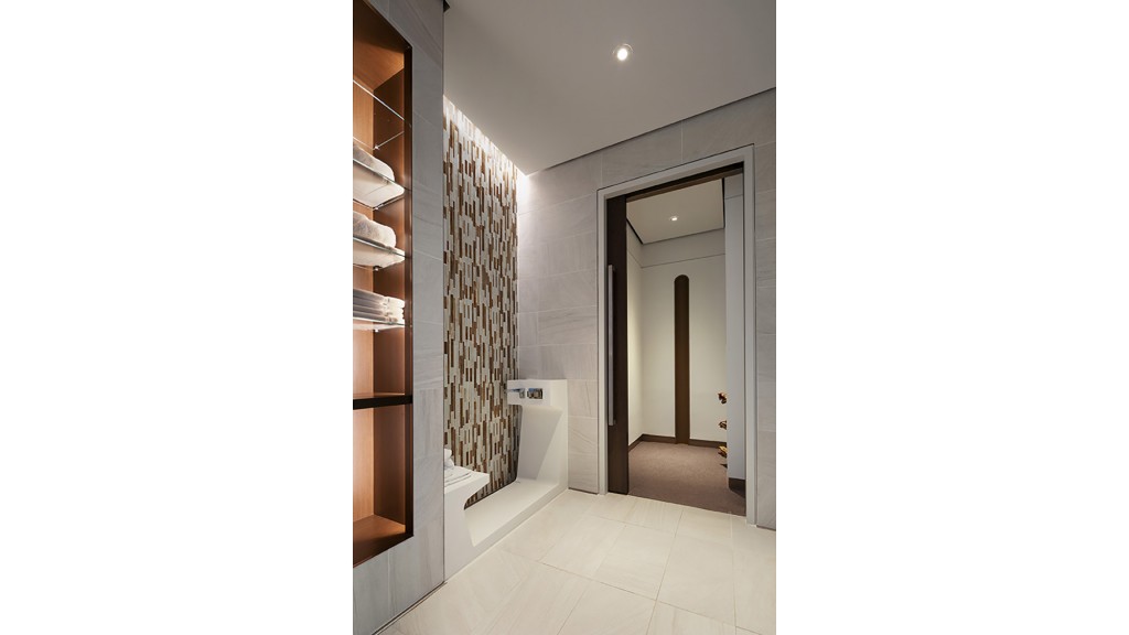 A bathroom with a shower and shelves.